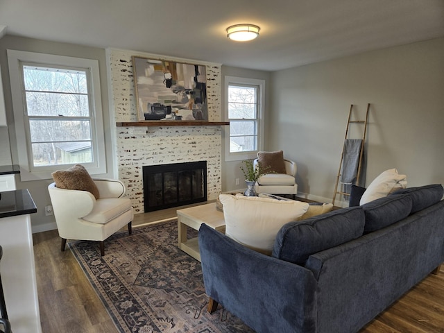 living room featuring a fireplace, dark wood finished floors, and baseboards