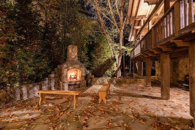 exterior space with an outdoor stone fireplace and a patio area