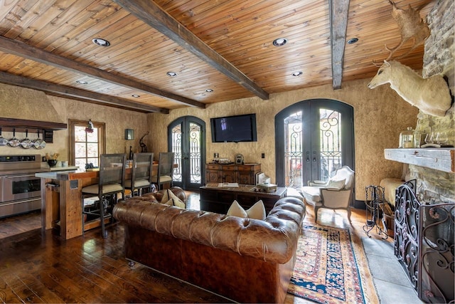 living room featuring beamed ceiling, wooden ceiling, a fireplace, and french doors