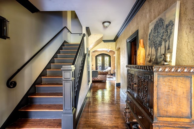 staircase featuring hardwood / wood-style flooring, crown molding, and french doors