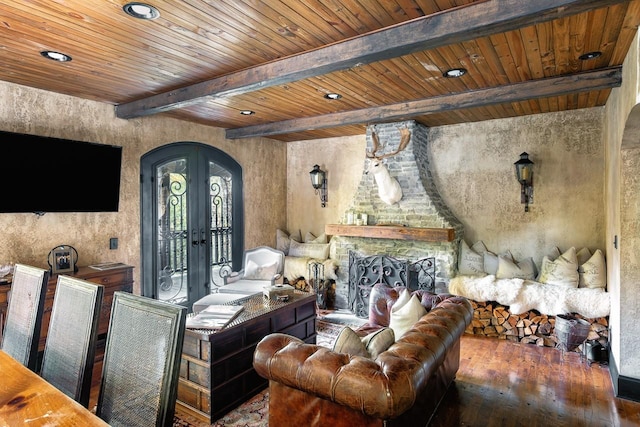 living room with a fireplace, hardwood / wood-style flooring, wooden ceiling, beam ceiling, and french doors