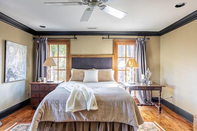 bedroom featuring hardwood / wood-style flooring, ornamental molding, and ceiling fan