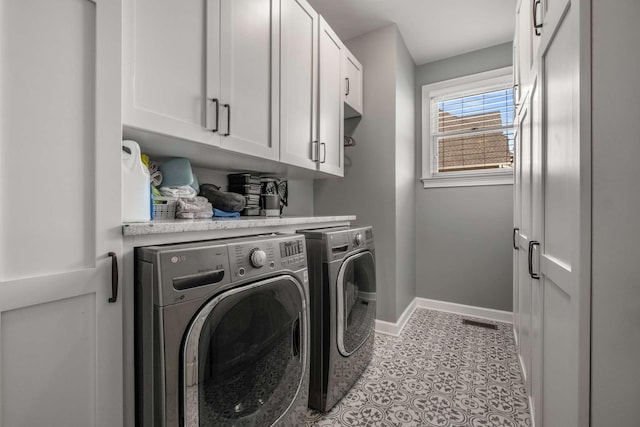 laundry room featuring cabinets, washer and dryer, and light tile patterned floors