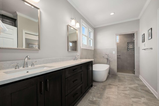 bathroom featuring ornamental molding, a freestanding bath, tiled shower, and a sink