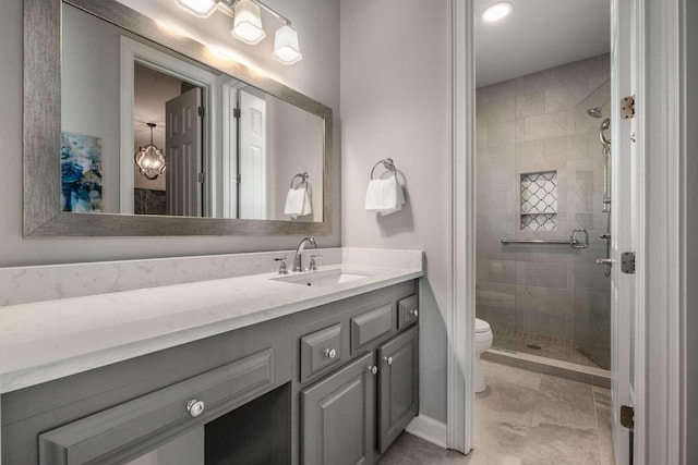 bathroom featuring vanity, tiled shower, and toilet