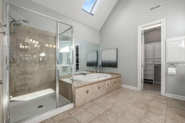 bathroom featuring tile patterned flooring, plus walk in shower, and vaulted ceiling with skylight