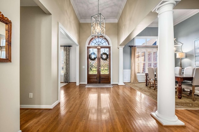 foyer entrance with ornate columns and hardwood / wood-style flooring