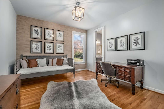 office area featuring an inviting chandelier and light hardwood / wood-style floors