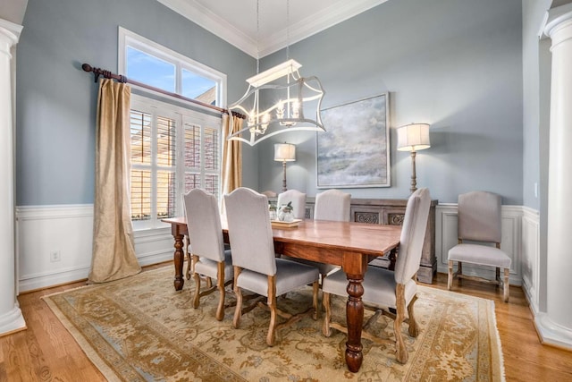 dining room featuring decorative columns, ornamental molding, a healthy amount of sunlight, and light hardwood / wood-style floors