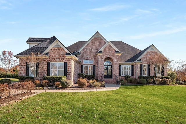 view of front facade with brick siding and a front yard