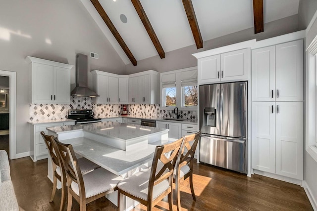 kitchen featuring tasteful backsplash, dark wood-type flooring, wall chimney range hood, stainless steel appliances, and a sink