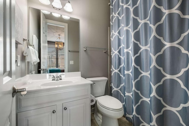 bathroom with curtained shower, vanity, toilet, and a chandelier