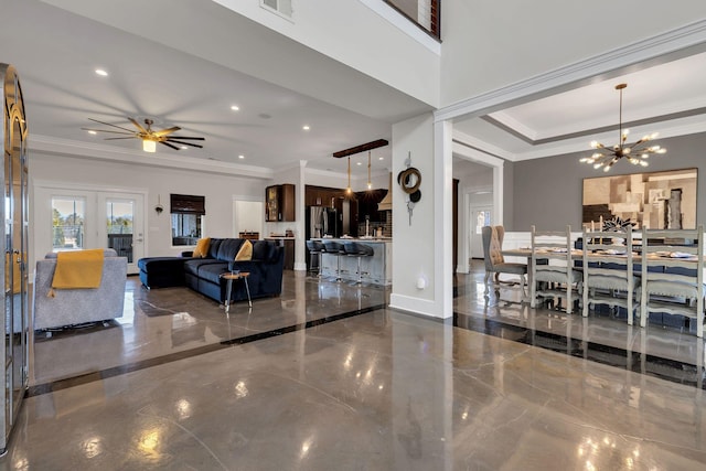 living room featuring ceiling fan with notable chandelier, ornamental molding, and a raised ceiling