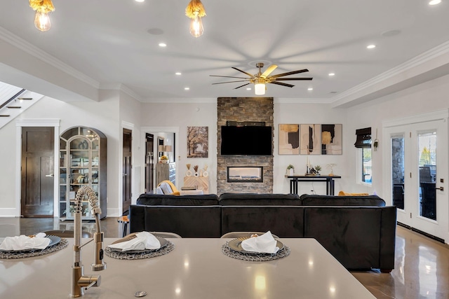 kitchen with crown molding, ceiling fan, and a fireplace