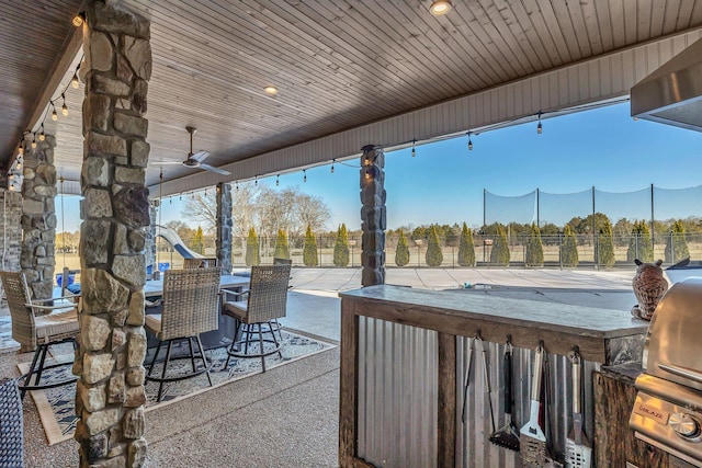 view of patio featuring ceiling fan, exterior bar, and a mountain view