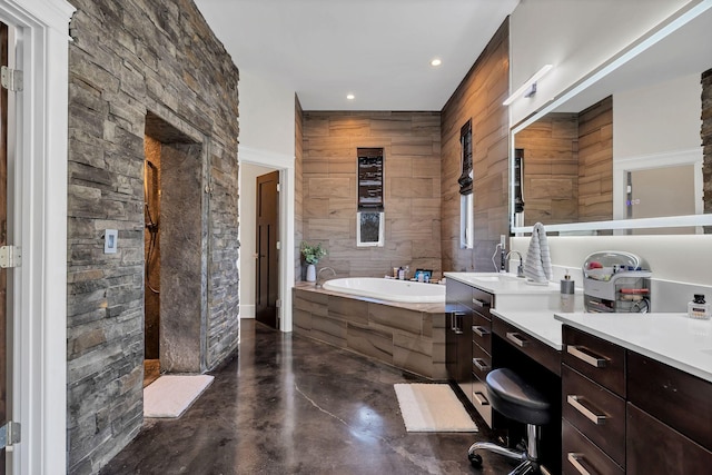 bathroom featuring vanity, a bath, and concrete floors