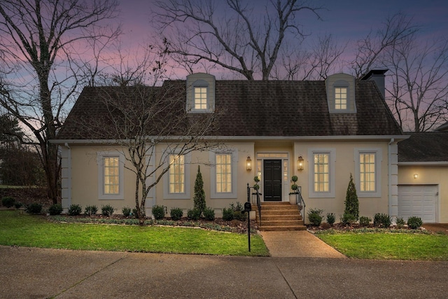 new england style home with a garage and a lawn