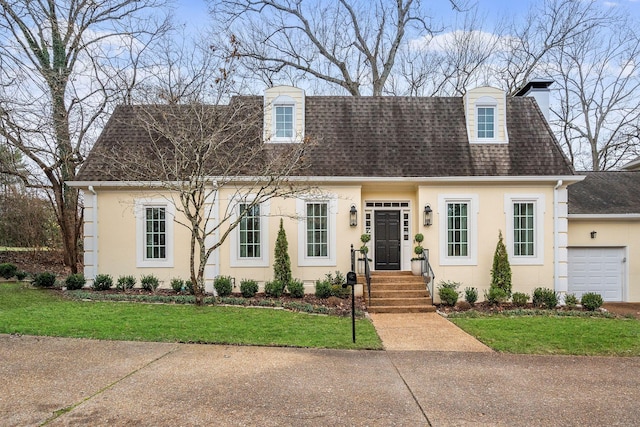 cape cod house featuring a garage and a front yard