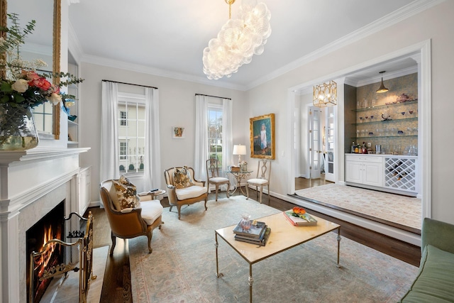 interior space with wood-type flooring, ornamental molding, a high end fireplace, an inviting chandelier, and built in shelves