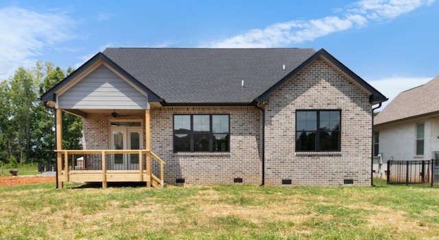 back of property with a wooden deck and a yard