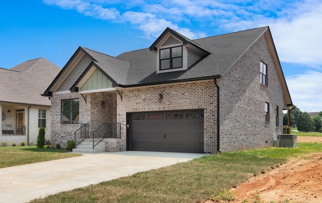 view of front of property with a garage, a front yard, and central air condition unit