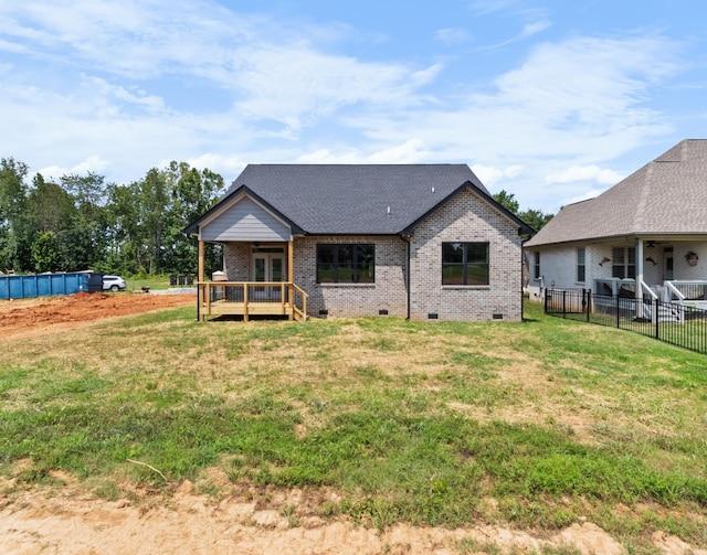 rear view of property featuring a wooden deck and a yard