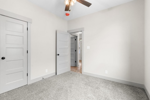 unfurnished bedroom with light colored carpet, ceiling fan, and a closet