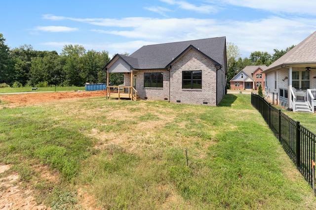 back of house with a wooden deck and a yard