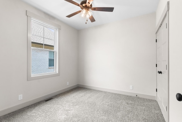 carpeted spare room with ceiling fan