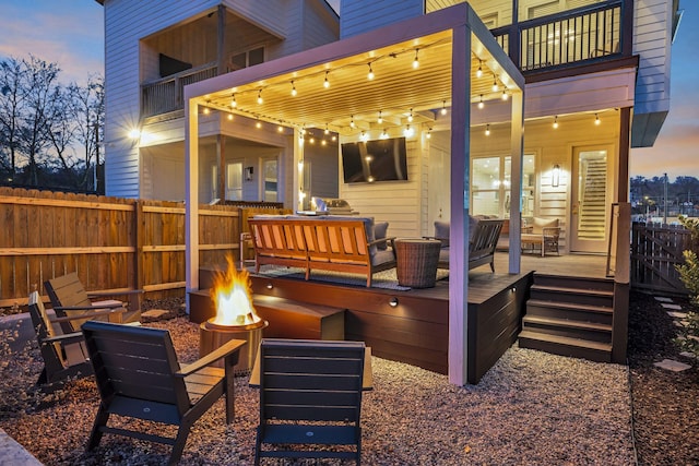 wooden terrace featuring an outdoor living space with a fire pit and a pergola