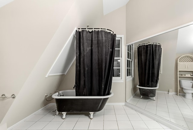 bathroom featuring a tub to relax in, toilet, and tile patterned flooring