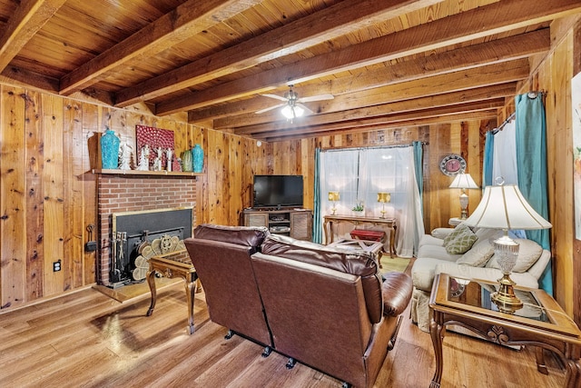 living room with wood walls, wood ceiling, beam ceiling, and a fireplace