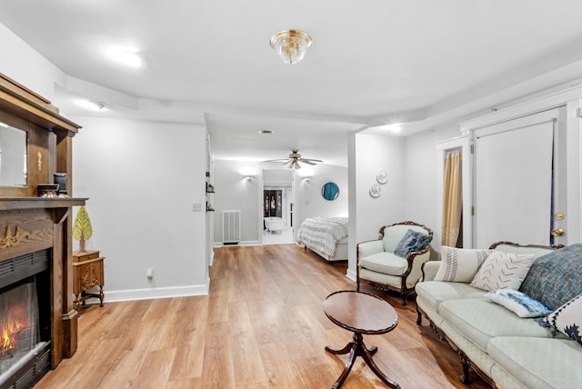 living room with light hardwood / wood-style flooring and ceiling fan