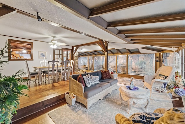 living room featuring wood-type flooring, lofted ceiling with beams, and ceiling fan