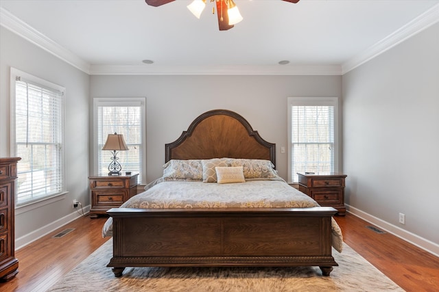 bedroom with crown molding, light hardwood / wood-style floors, and ceiling fan