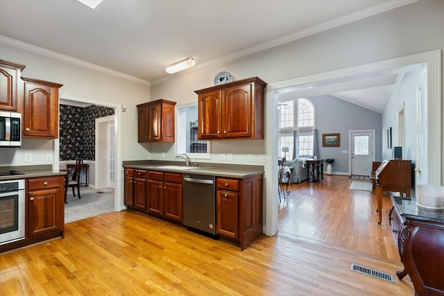 kitchen with ornamental molding, stainless steel appliances, sink, and light hardwood / wood-style flooring