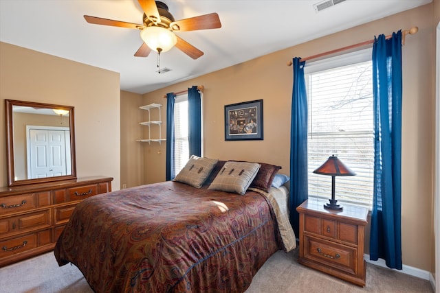 carpeted bedroom featuring multiple windows and ceiling fan