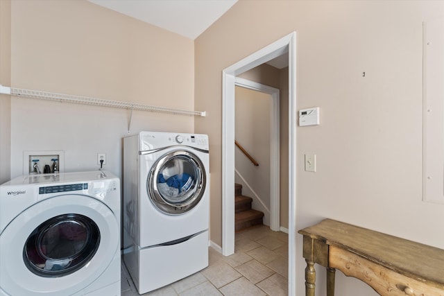 laundry area with light tile patterned floors and washer and clothes dryer