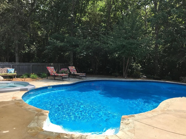 view of swimming pool featuring a patio and an in ground hot tub