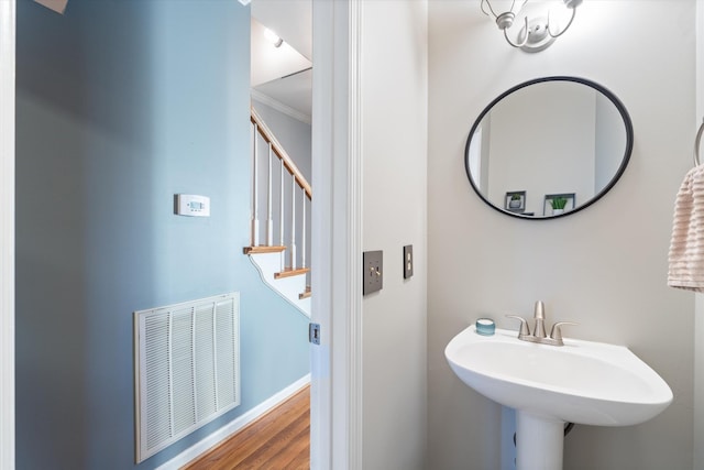 bathroom with ornamental molding, wood-type flooring, and sink