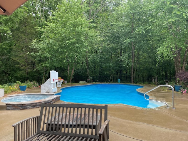 view of pool with a patio area and an in ground hot tub