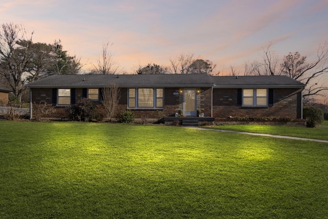 ranch-style home with a lawn