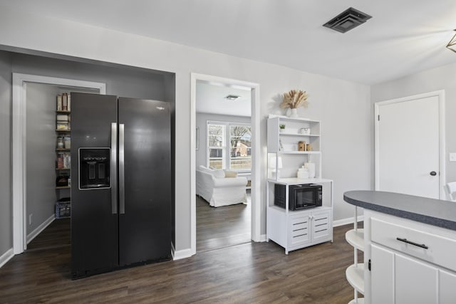 kitchen with white cabinets, dark hardwood / wood-style flooring, and stainless steel fridge with ice dispenser