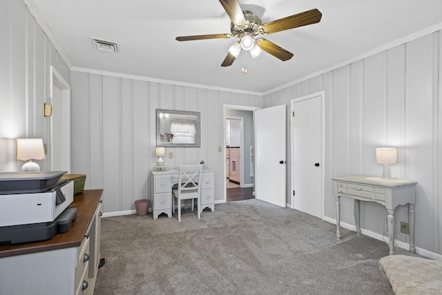 carpeted home office featuring crown molding and ceiling fan