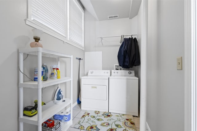 laundry area featuring separate washer and dryer and light tile patterned floors