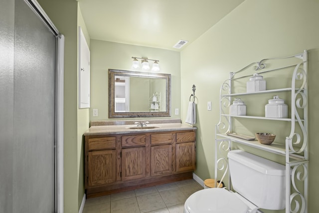 bathroom featuring vanity, an enclosed shower, tile patterned floors, and toilet