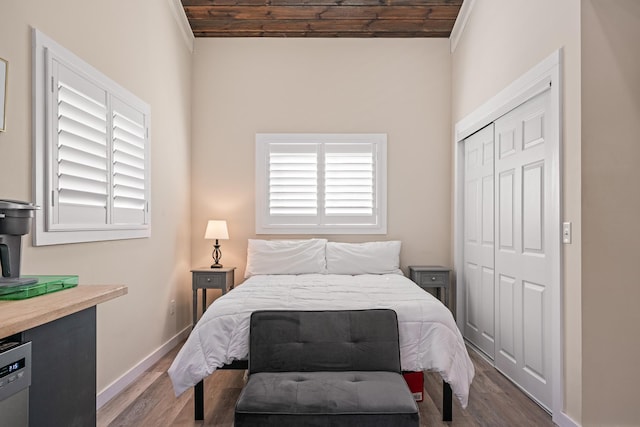 bedroom with a closet, wood ceiling, and dark hardwood / wood-style floors