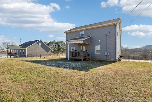 back of property featuring a wooden deck and a yard