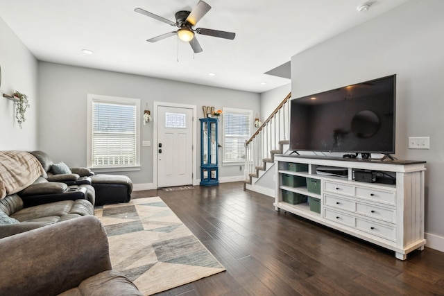 living room with dark wood-type flooring, ceiling fan, and plenty of natural light