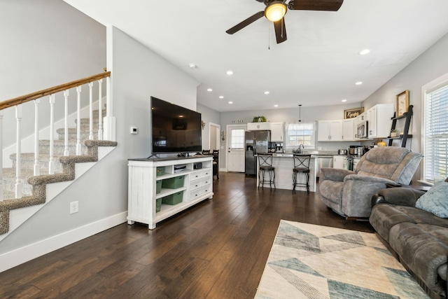 living room with dark hardwood / wood-style flooring, sink, and ceiling fan